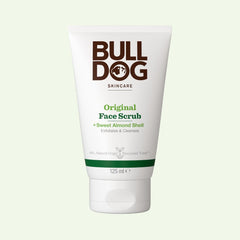 A white 125 ml tube of Original Face Scrub for men, made with sweet almond shell and natural origin ingredients, stands upright against a pale background. The front displays green and brown text.