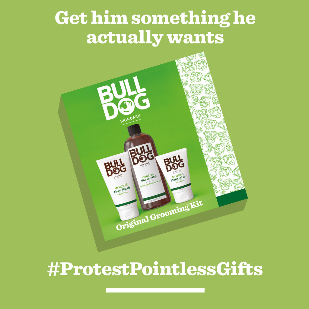 A green gift box of the Original Grooming Kit for men with face wash, moisturizer, and scrub. Text above: "Get him something he actually wants." Below: "#ProtestPointlessGifts." The perfect skincare gift for men!.